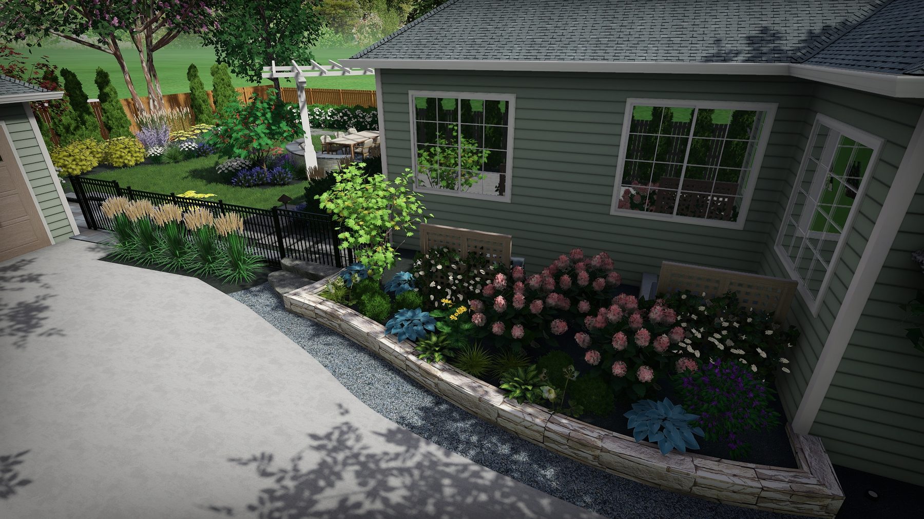 Curved stone-edged planting bed with hydrangeas and ornamental grasses alongside a driveway, designed by Topo d'Oro Landscape Design